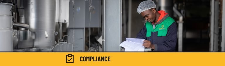 A man distilling essential oils and holding documentation.